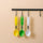 LCD Digital Spoon Scale UK in yellow, green, and white hanging on a rack, perfect for precise cooking measurements.